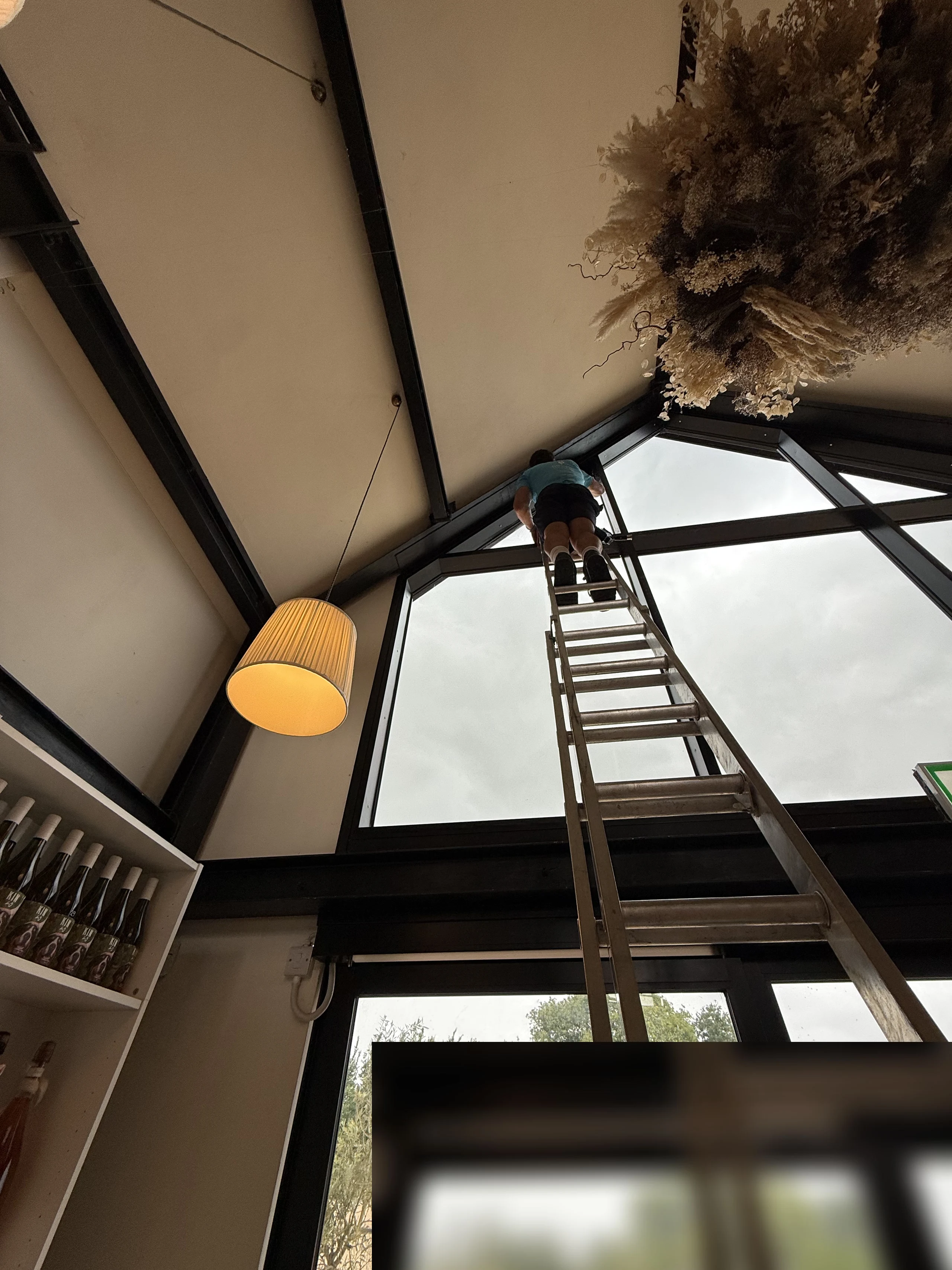 Ladder work cleaning the glazed apex inside a commercial barn venue