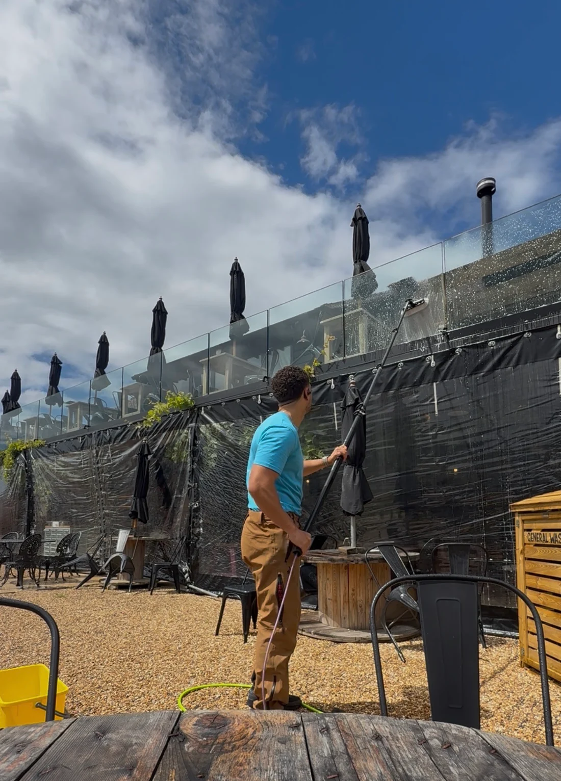 GWC operative cleaning a commercial glass balustrade with a water-fed pole